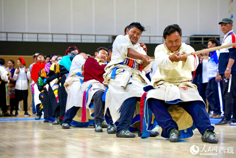 身著民族服裝的農(nóng)牧民選手在拔河比賽現(xiàn)場。