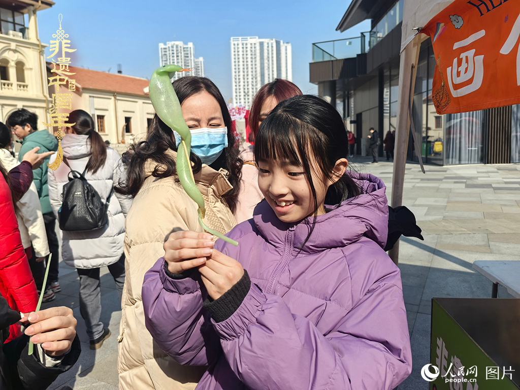 2025年1月29日，湖北武漢的新春廟會上，小朋友拿著吹制好的糖人，十分開心。人民網(wǎng)記者 張沛攝