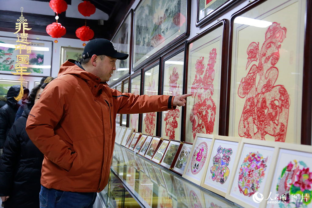 2025年1月23日，游客在天津楊柳青古鎮(zhèn)欣賞傳統(tǒng)剪紙作品，感受指尖上的古老藝術(shù)。人民網(wǎng)記者 崔新耀攝