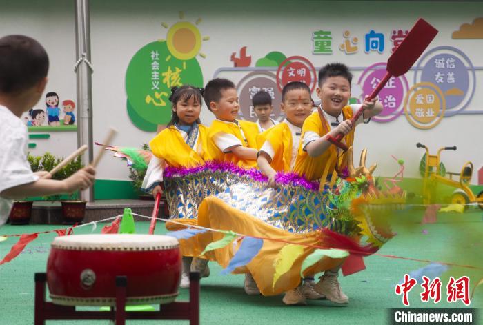 圖為龍舟賽游戲上，小伙伴們打鼓加油。　董觀生 攝