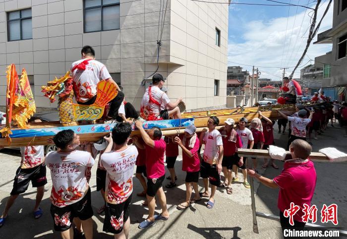 圖為5月29日，長樂江田鎮(zhèn)村民們肩扛著新龍舟舉行入水前游街儀式。　張斌 攝