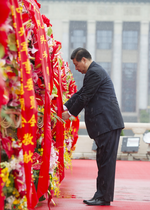2013年10月1日上午，在首都各界代表向人民英雄紀(jì)念碑敬獻(xiàn)花籃儀式上，習(xí)近平整理花籃上的緞帶。
